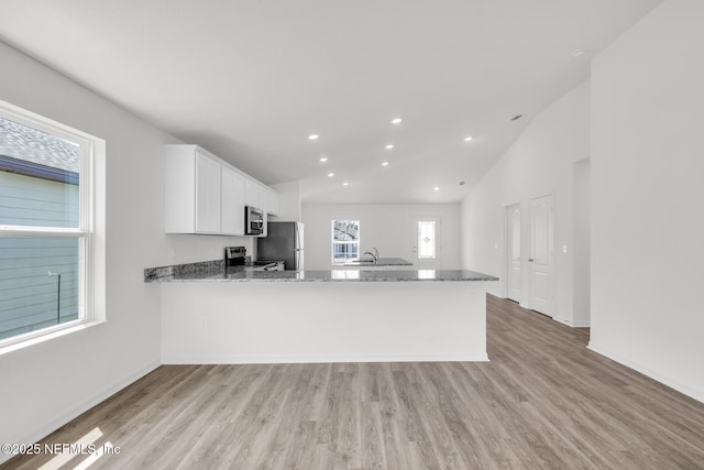 37343 Whisper Way, Hilliard, FL 32046 - kitchen with stainless steel appliances, light stone countertops, light wood finished floors, white cabinetry, and recessed lighting
