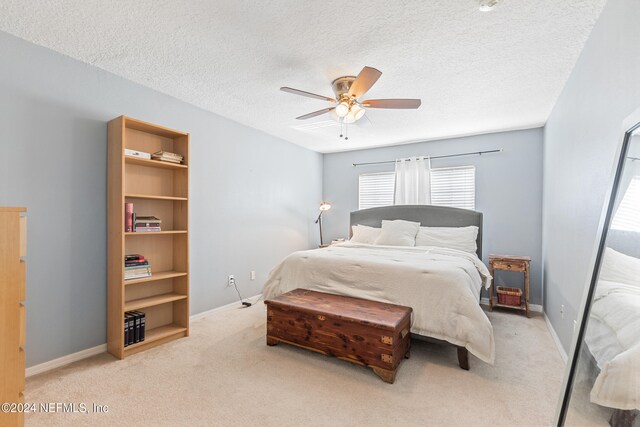 carpeted bedroom with a textured ceiling and ceiling fan