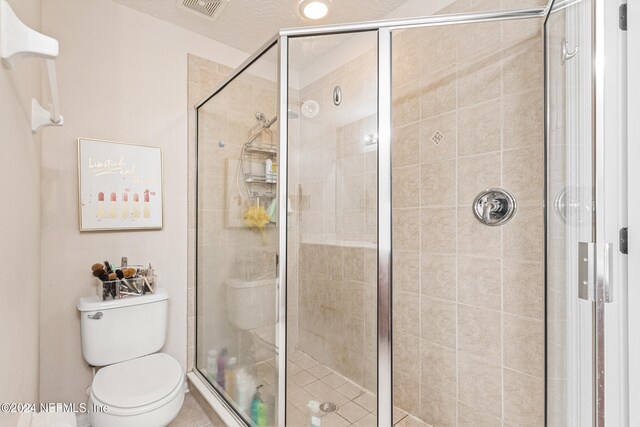 bathroom featuring toilet and a shower with door