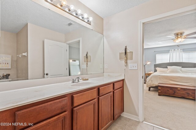 bathroom featuring vanity, a textured ceiling, tile patterned flooring, and ceiling fan