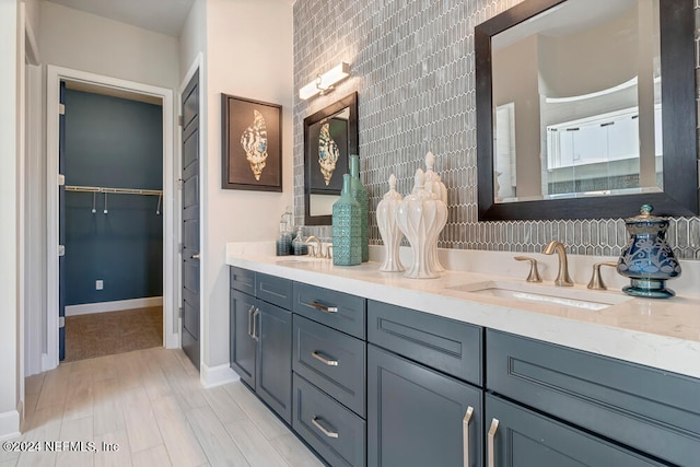 bathroom with wood-type flooring, vanity, and backsplash