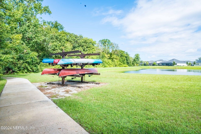 view of property's community with a water view and a yard