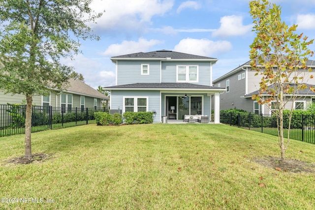 rear view of property featuring a lawn and a patio area