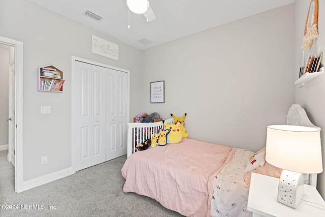 bedroom featuring ceiling fan, light carpet, and a closet