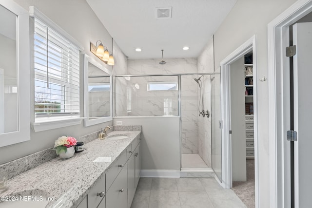 bathroom with walk in shower, tile patterned flooring, and vanity