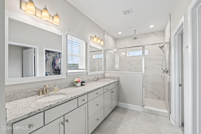 bathroom with walk in shower, plenty of natural light, vanity, and tile patterned floors