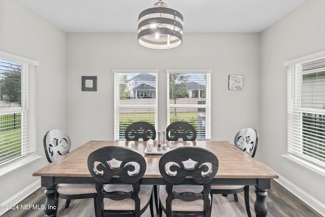 dining space with dark wood-type flooring and a chandelier