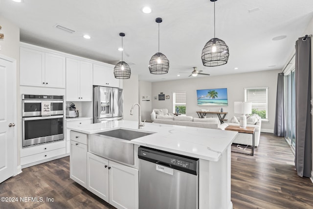 kitchen featuring stainless steel appliances, a center island with sink, sink, white cabinets, and dark hardwood / wood-style flooring