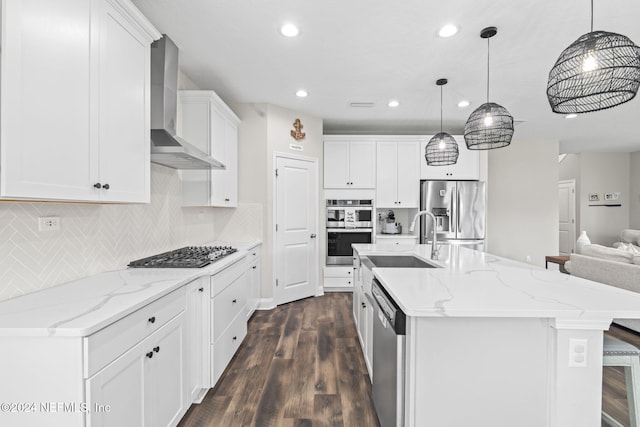 kitchen featuring white cabinets, sink, dark hardwood / wood-style floors, wall chimney range hood, and appliances with stainless steel finishes