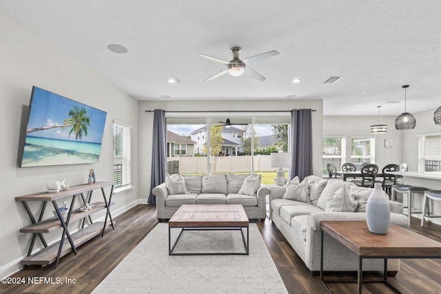 living room with dark hardwood / wood-style flooring and ceiling fan