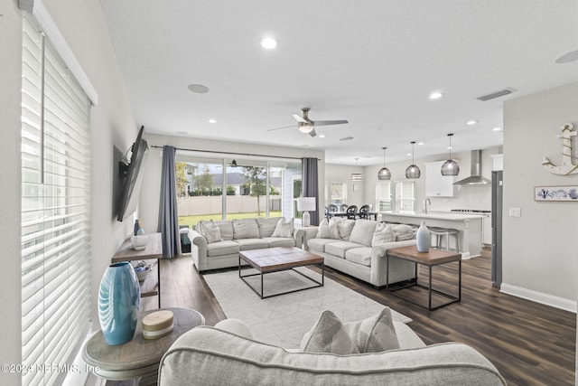 living room with sink, wood-type flooring, and ceiling fan