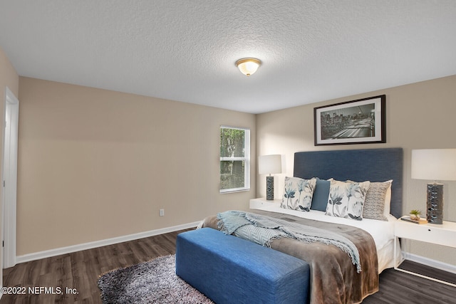 bedroom featuring dark hardwood / wood-style flooring and a textured ceiling