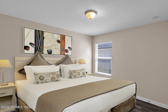 bedroom featuring a textured ceiling and dark hardwood / wood-style floors