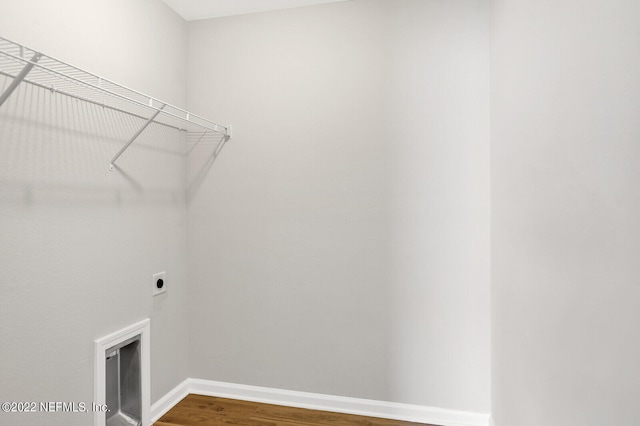 washroom with hardwood / wood-style flooring and hookup for an electric dryer