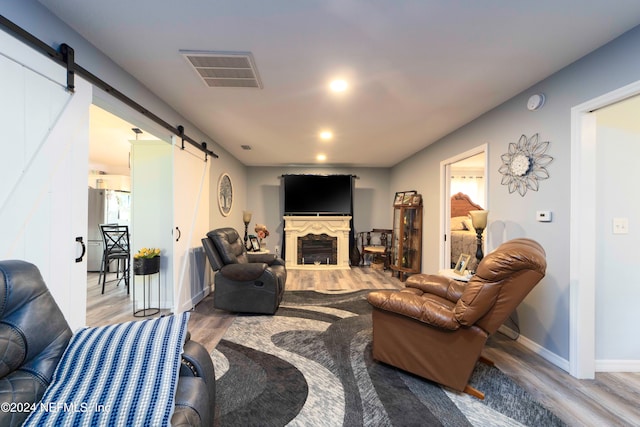 living room with a barn door and hardwood / wood-style floors