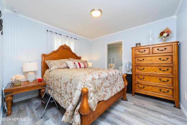 bedroom with ornamental molding and light hardwood / wood-style flooring