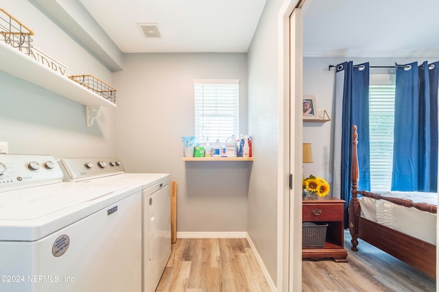 washroom with separate washer and dryer and light hardwood / wood-style flooring