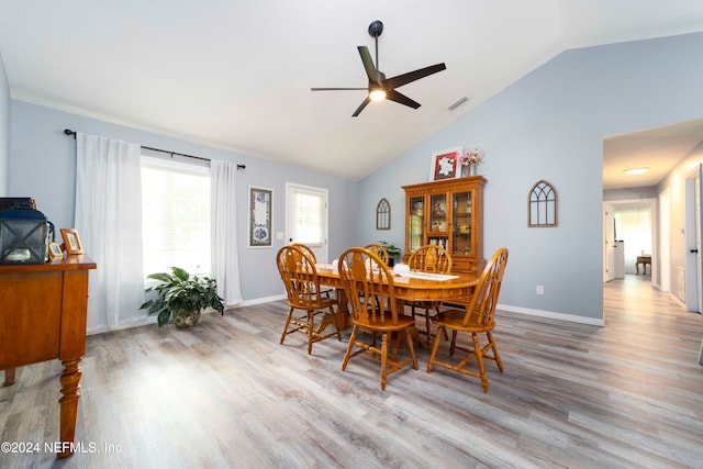 dining room with ceiling fan, light wood-type flooring, and lofted ceiling