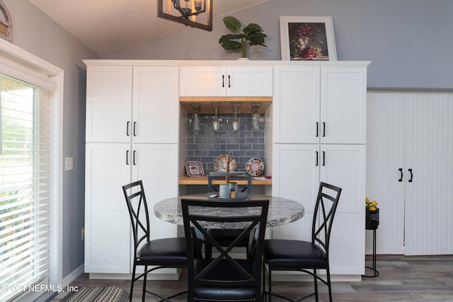 dining area with dark hardwood / wood-style flooring and lofted ceiling