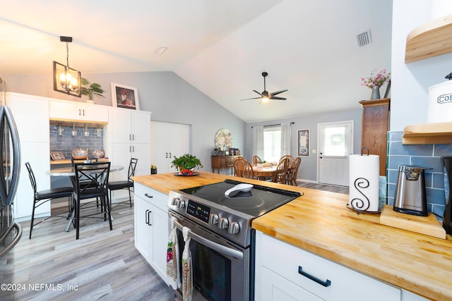 kitchen featuring wooden counters, white cabinetry, stainless steel range with electric cooktop, and decorative light fixtures