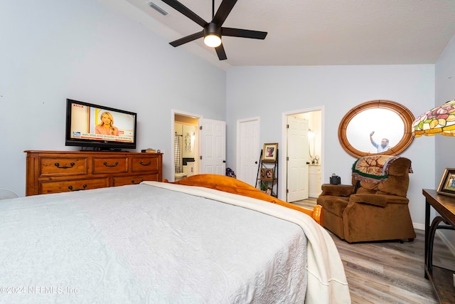 bedroom with light wood-type flooring, ceiling fan, high vaulted ceiling, and connected bathroom