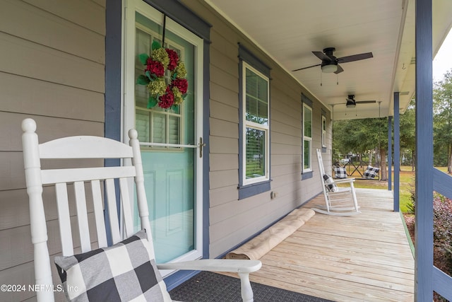 wooden deck featuring covered porch and ceiling fan