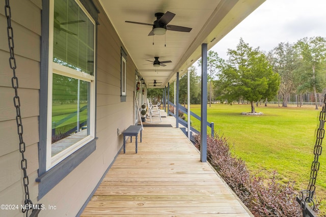 deck featuring covered porch, ceiling fan, and a yard