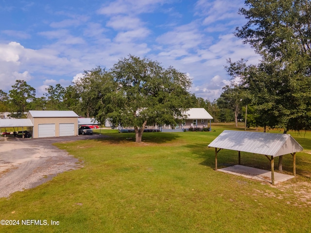 view of yard with a garage, an outdoor structure, and a carport