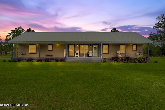 view of front of property with a porch and a yard