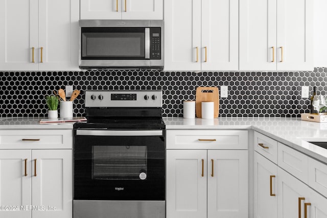 kitchen with white cabinets, decorative backsplash, and stainless steel appliances