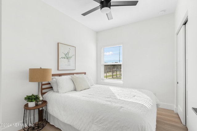 bedroom featuring ceiling fan, a closet, and light hardwood / wood-style flooring