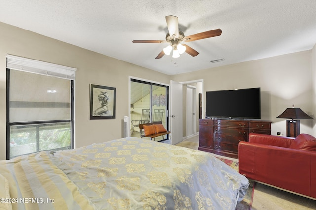 bedroom with access to outside, a textured ceiling, and ceiling fan