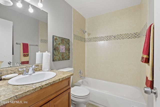 full bathroom with toilet, tiled shower / bath combo, and vanity