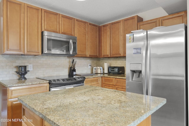 kitchen featuring decorative backsplash, stainless steel appliances, and a textured ceiling