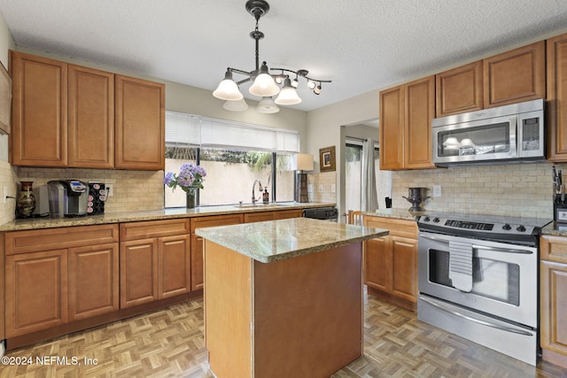 kitchen with stainless steel appliances, a center island, decorative backsplash, sink, and decorative light fixtures