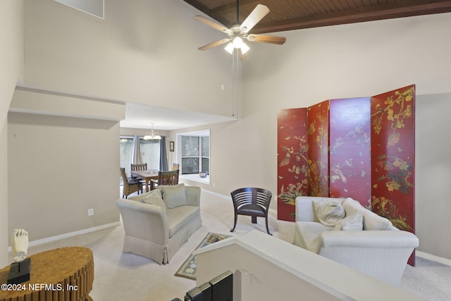 living room with ceiling fan with notable chandelier, light colored carpet, wooden ceiling, beamed ceiling, and a high ceiling