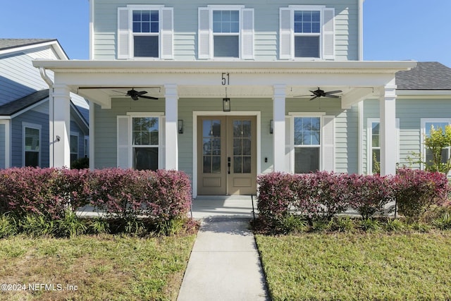 view of exterior entry featuring ceiling fan and a yard