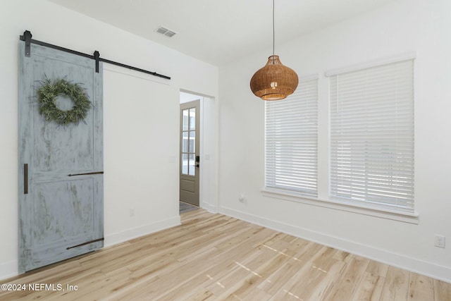 interior space featuring light wood-type flooring and a barn door