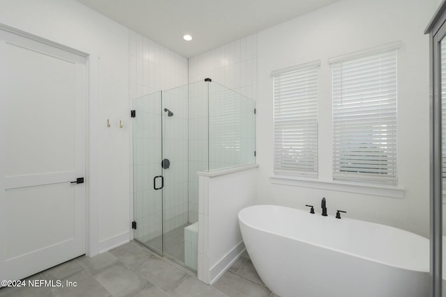 bathroom with tile patterned floors and independent shower and bath