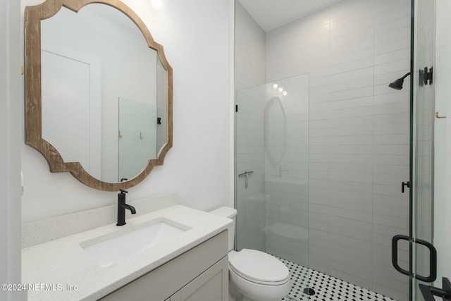 bathroom with vanity, toilet, and a shower with shower door