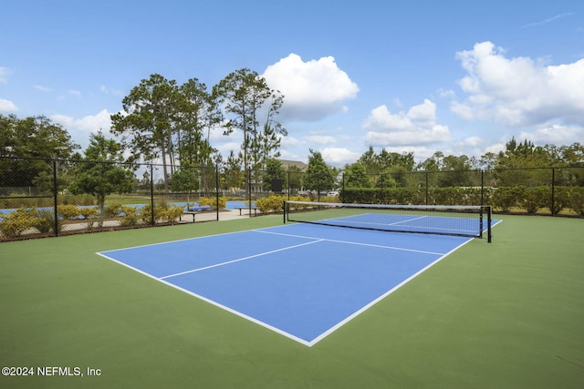 view of tennis court featuring basketball hoop