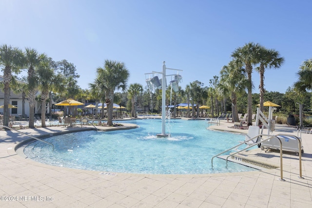 view of pool with pool water feature and a patio