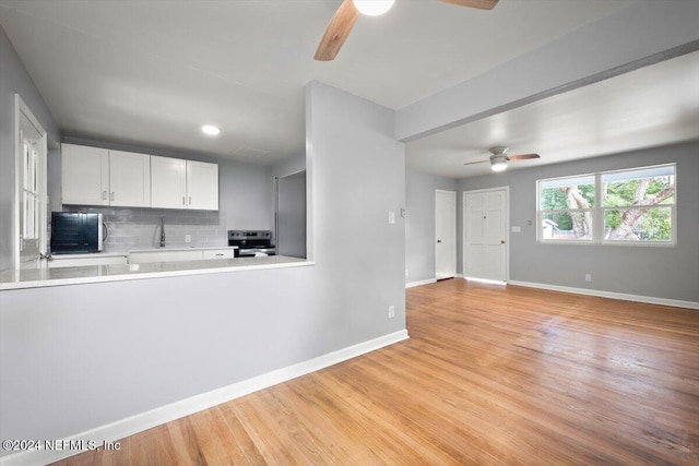 kitchen featuring white cabinetry, tasteful backsplash, ceiling fan, stainless steel electric range, and light hardwood / wood-style flooring