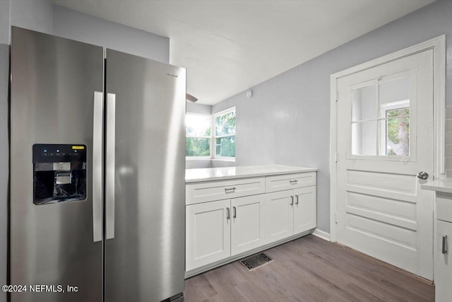 kitchen with white cabinetry, stainless steel refrigerator with ice dispenser, and light wood-type flooring