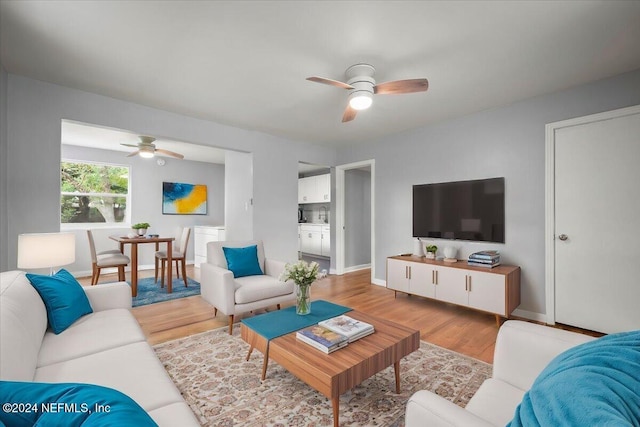 living room featuring light wood-type flooring and ceiling fan