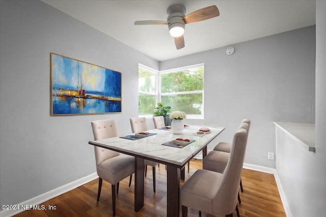 dining area with wood-type flooring and ceiling fan