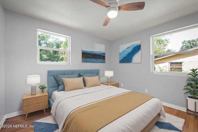 bedroom with hardwood / wood-style flooring, multiple windows, and ceiling fan