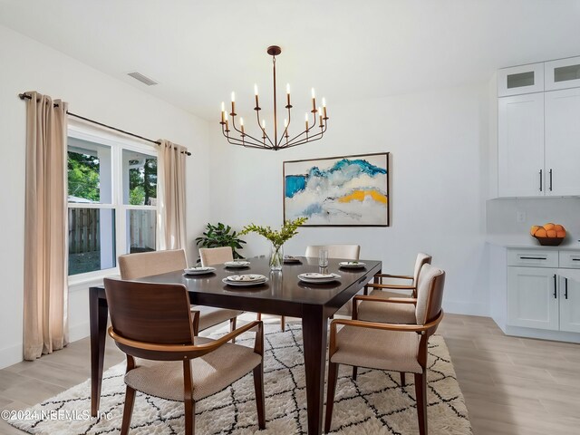 dining space featuring an inviting chandelier and light wood-type flooring