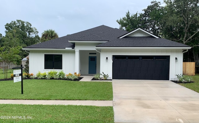 view of front of property with a garage and a front lawn