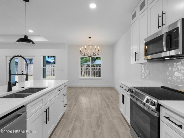 kitchen featuring light stone countertops, white cabinetry, sink, and appliances with stainless steel finishes